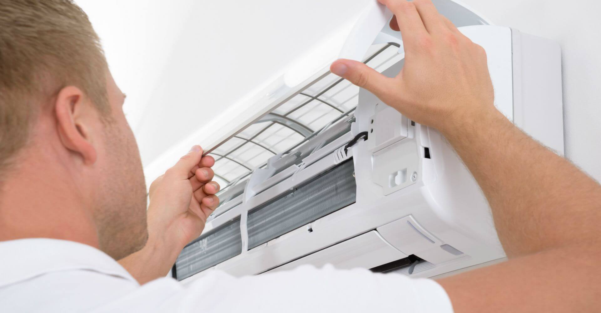 Professional technician repairing an air conditioning unit in a residential home in Sharjah, UAE, ensuring efficient cooling during peak summer.