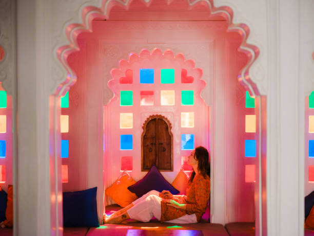 Why You Should Hire Wall Painting Services in Dubai? Woman relaxing in a vibrant, colorfully painted interior with traditional wall design – inspiration for artistic and cultural wall painting services in Dubai.