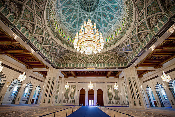 Beyond the Brush: What Sets Professional Painting Services in Dubai? Intricately designed mosque interior featuring ornate chandeliers and domed ceiling – a prime example of surfaces ideal for professional painting services in Dubai.